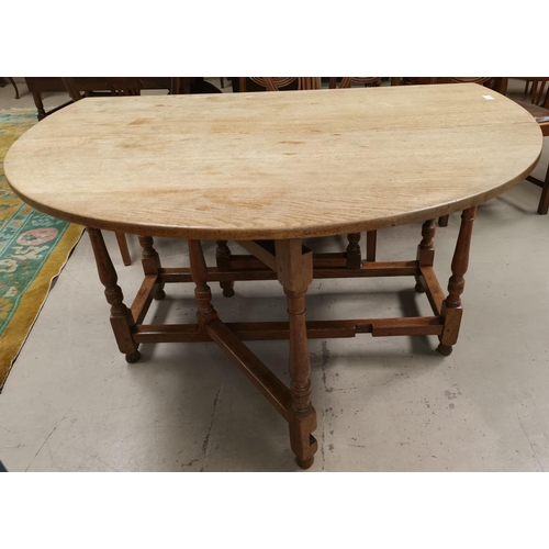 532 - A 1930's oak oval drop leaf dining table