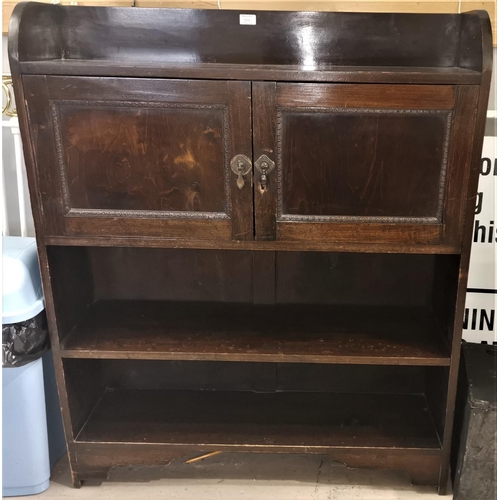 588 - A 1920's oak bookcase with 2 panelled door cupboards and shelves, height 48
