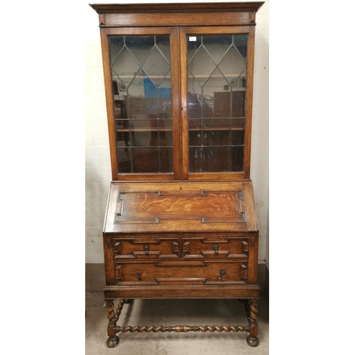 589 - An oak Jacobean style bureau bookcase with beaded glass cupboard over panelled fall front, 2 drawers... 