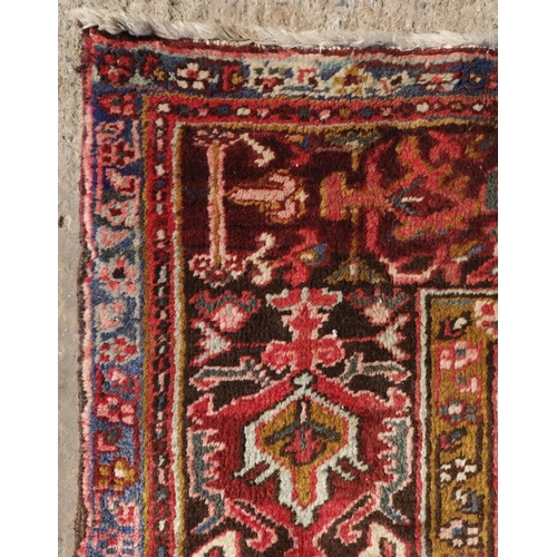 628 - A large hand knotted rust ground carpet with geometric pattern, 137
