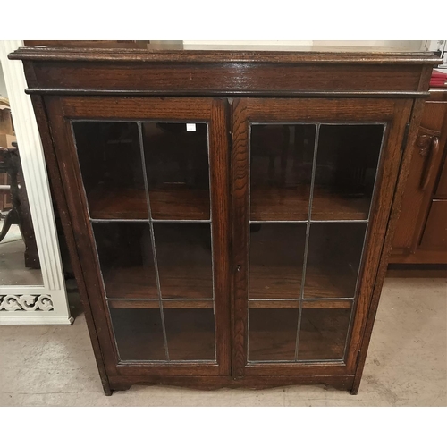 637 - A 1930's oak display cabinet with double leaded glass doors, height 39