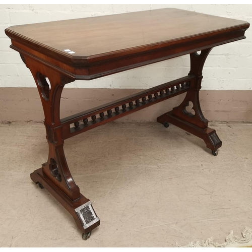 646 - A late 19th / early 20th century walnut Gothic style library table with carved and pierced supports ... 