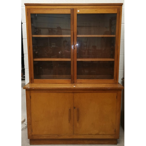 635 - A mid 20th century golden oak bookcase with glazed top above double cupboard, wedge shaped handles, ... 