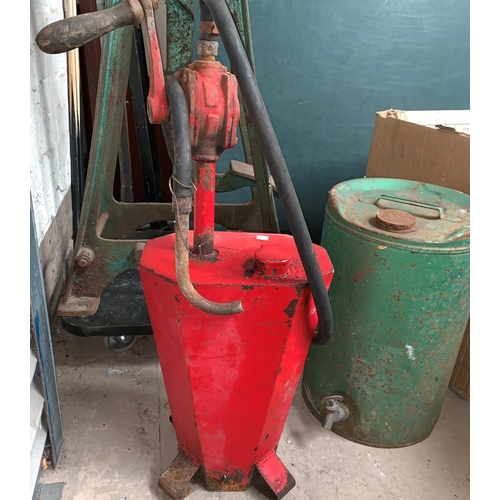 460A - A vintage red painted petrol pump with twin handle and a similar oil
