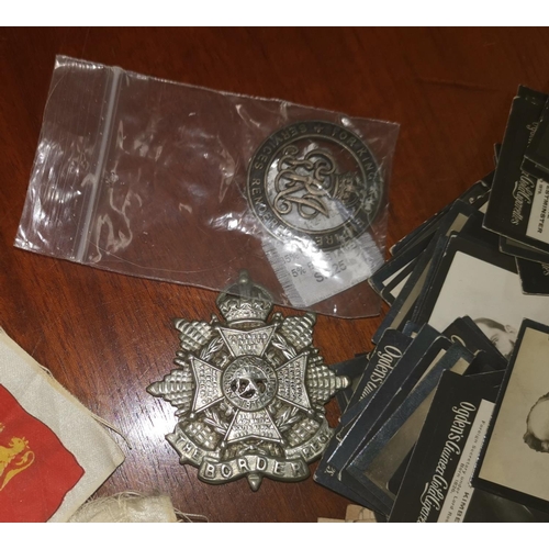 429 - A WWI Silver War Badge; a Border Reg cap badge; a quantity of Ogden's cigarette cards; various silk ... 