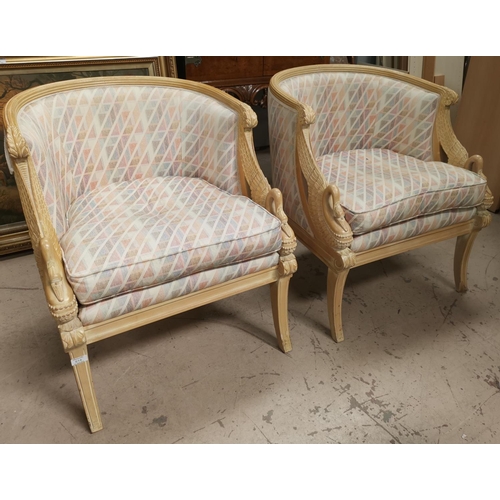 614A - A pair of reproduction Empire style tub chairs in limed wood with carved swans, upholstered in multi... 