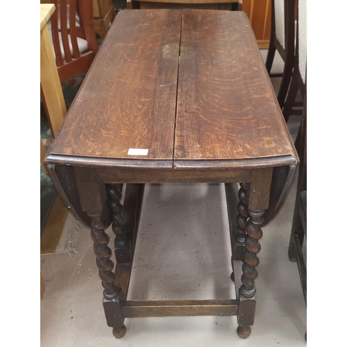 609 - A 1920's oak oval dropleaf dining table with barleytwist supports