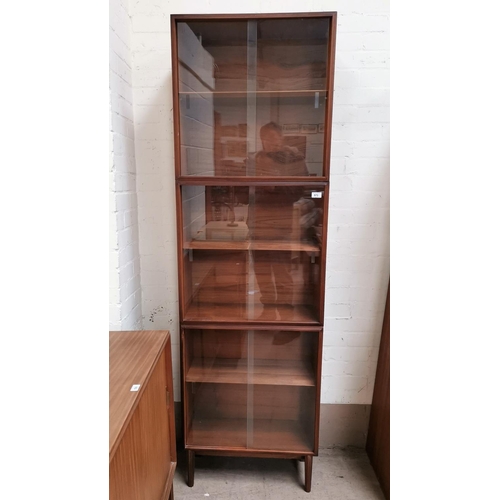 573 - A 1960's teak full height bookcase enclosed by 3 pairs of sliding doors