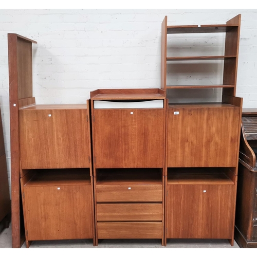 581 - A 1960's 8 piece modular wall unit in teak and white laminate:  5 single door cupboards; drawer unit... 