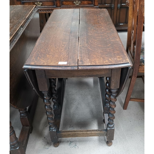 609 - A 1920's oak oval dropleaf dining table with barleytwist supports