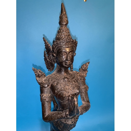 245 - A Thai bronze figure of a goddess with hands folded in prayer and long tail on wooden plinth, height... 