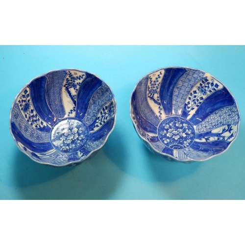 227 - A Chinese / Japanese pair of rice bowls of spiral fluted form, decorated with alternating blue and w... 