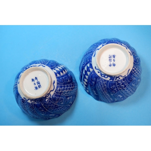 227 - A Chinese / Japanese pair of rice bowls of spiral fluted form, decorated with alternating blue and w... 