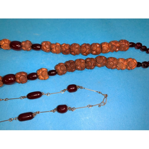 313A - A cherry amber coloured Bakelite and wooden graduating beaded necklace, largest bead 25mm; another s... 