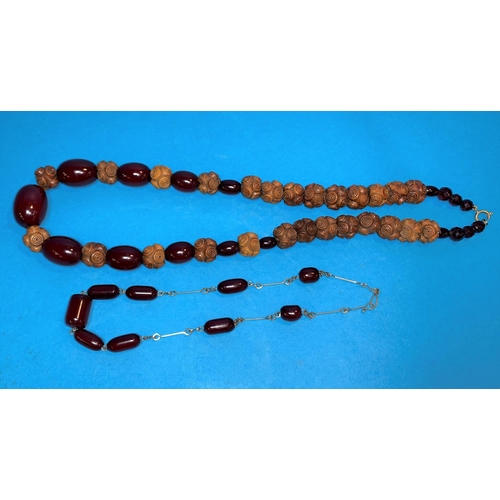 313A - A cherry amber coloured Bakelite and wooden graduating beaded necklace, largest bead 25mm; another s... 