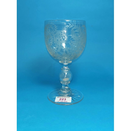 223 - A mid Victorian engraved glass goblet, multi-knop stem with bubble containing a silver 3d, dated 186... 
