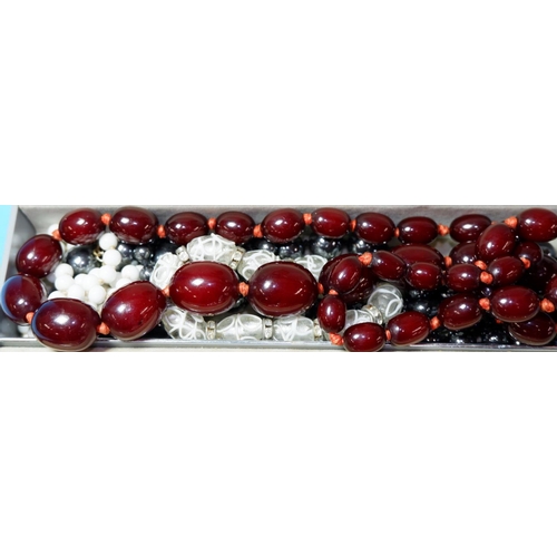 301 - A necklace of graduated cherry amber coloured beads largest approx 2cm weight 61gm; various others