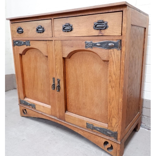 645 - An oak Arts and Crafts side cabinet with double drawers and cupboards with copper fittings