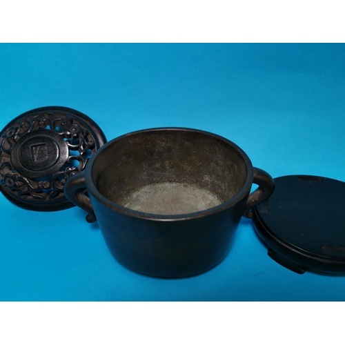 284 - An oval bronze 2 handled Chinese censor with pierced lid, relief character signature to base and har... 