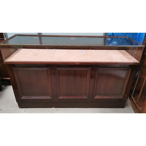 572 - An early/mid 20th century shop display counter with glazed upper section and open shelves under, wit... 