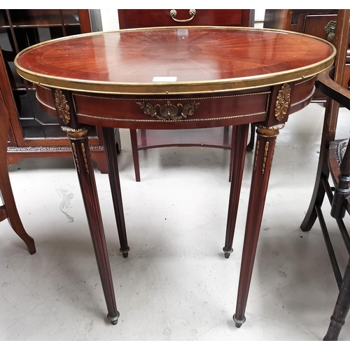 542 - An Empire style oval occasional table with quarter veneered top and gilt metal mounts, on turned flu... 