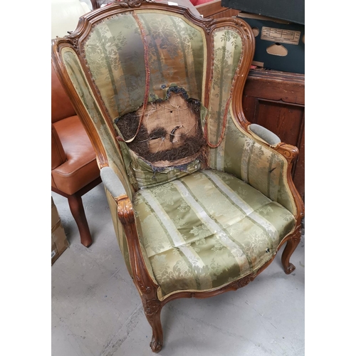 603 - An early 20th century wing back armchair, Louis XV style acanthus carved walnut (requires reupholste... 