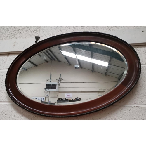 638 - An oval bevelled edge wall mirror in beaded mahogany frame