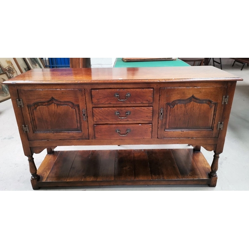 560 - A Georgia style distressed oak dresser base in the style of Titchmarsh & Godwin, having 3 central dr... 