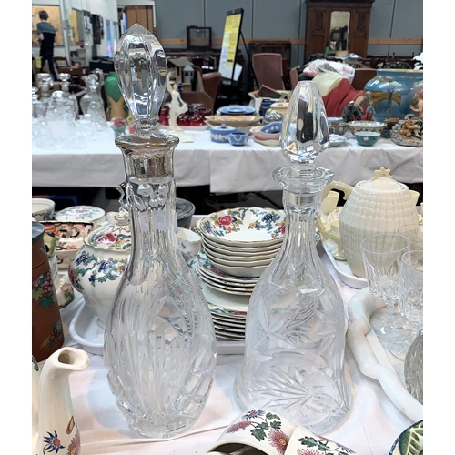 192 - A cut glass decanter with silver rim, stamped '925'; another cut glass decanter