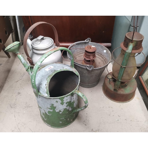 490 - Two vintage hurricane lamps; a watering can; bucket and aluminium kettle; a wrought iron panel