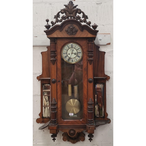 563 - An unusual Vienna wall clock in walnut case, with ornate carved pediment and part side columns, hing... 