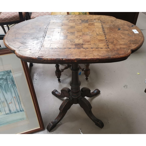565 - A Victorian inlaid games/occasional table, with shaped oval top on turned column an d 4 splay feet