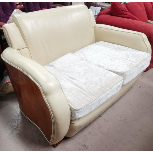 573 - An Art Deco 2 seater settee with exposed walnut fascia, in cream leather effect