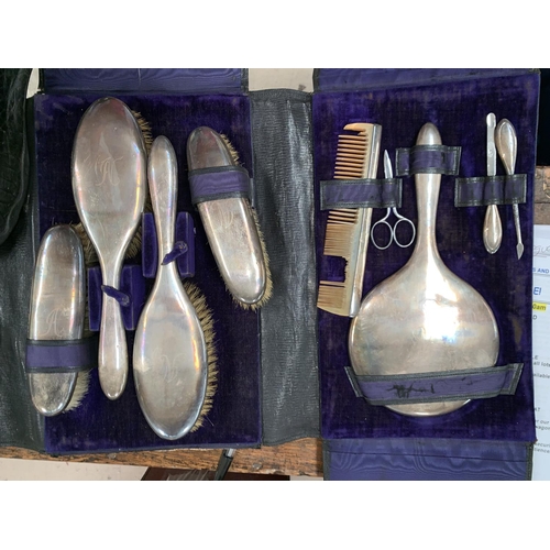 383 - A silver backed brush and mirror set in vanity case