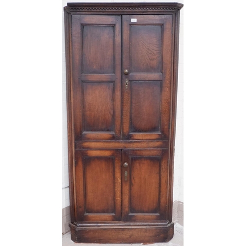611 - A 19th century oak full height corner cupboard enclosed by 2 pairs of panelled doors