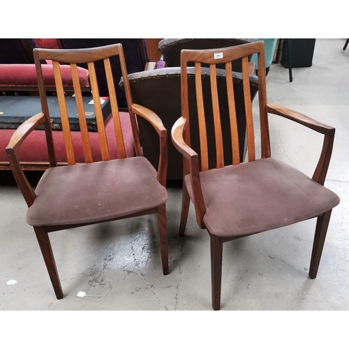 595 - A pair of G-Plan teak carver chairs with slat backs; A G-Plan teak extending dining table with shape... 