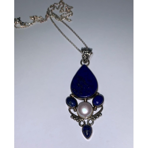 195a - An Art Nouveau style pendant on chain, stamped 925, set with lapis lazuli coloured stones and
centra... 