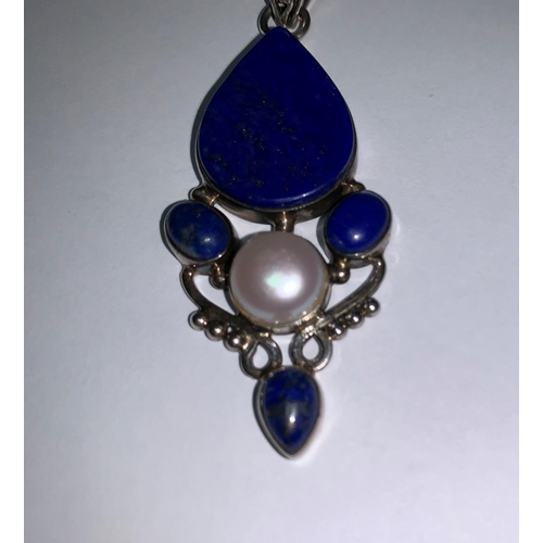 195a - An Art Nouveau style pendant on chain, stamped 925, set with lapis lazuli coloured stones and
centra... 