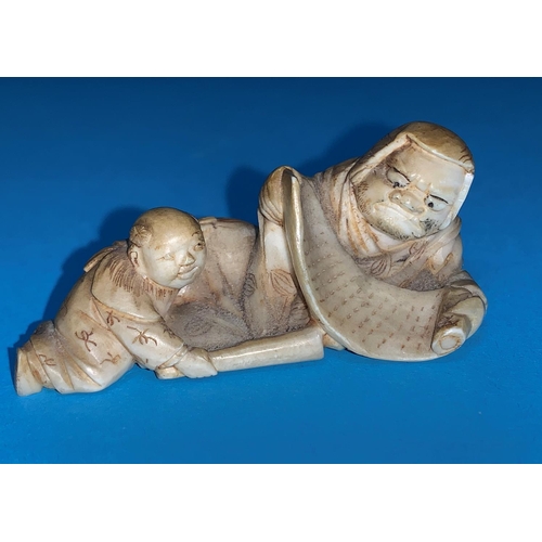 460 - A Meiji period netsuke depicting a man with scroll and child, length 6cm
