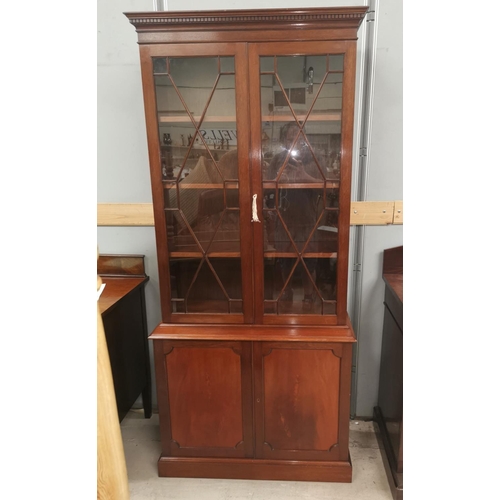 529 - A reproduction Georgian style mahogany bookcase with twin astragal glazed doors over cupboard enclos... 