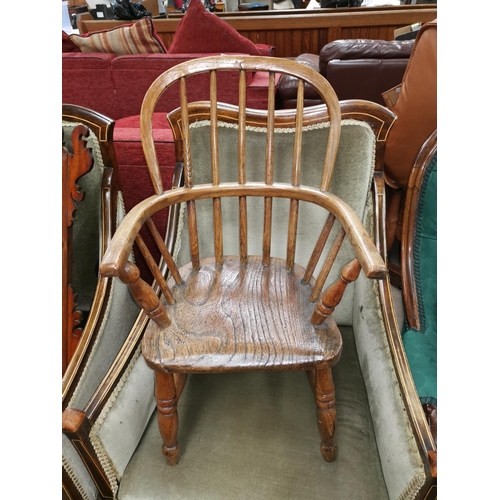 550 - A 19th century child's elm Windsor armchair with stick back and solid seat, on turned legs