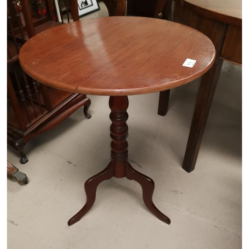 614 - An early 19th century mahogany wine table with circular tilt top, on turned column and triple feet