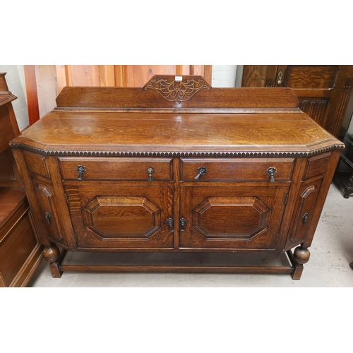 632 - A 1930's oak sideboard with 2 drawers and double cupboard enclosed by raised octagonal panel doors
