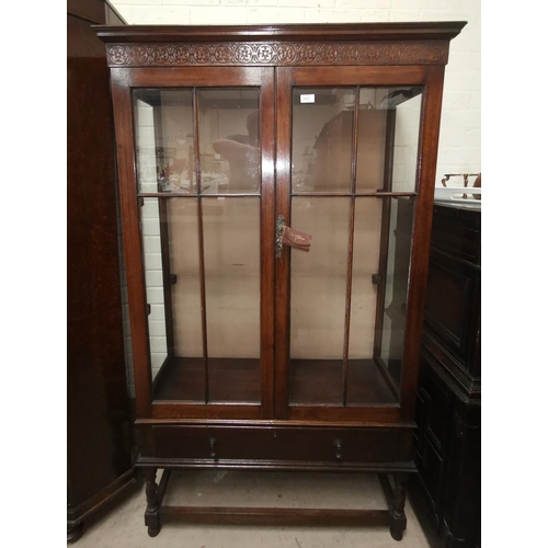 633 - A 1930's oak 2 door china cabinet with lower drawer and blind fret frieze, on barley twist legs