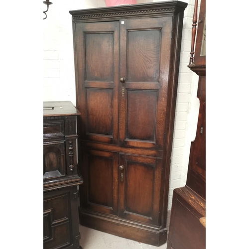 659 - A 19th century oak full height corner cupboard enclosed by 2 pairs of panelled doors