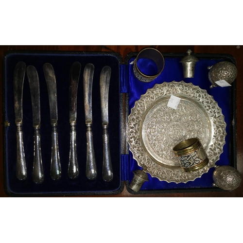 312 - A cased set of silver handle tea knives; an extensively chased Indian white metal dish; 2 pepper pot... 
