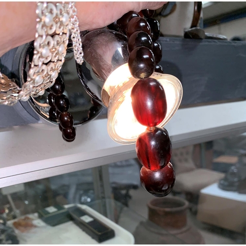 350 - A necklace of graduating dark cherry amber coloured beads with internal swirls largest bead approx 1... 