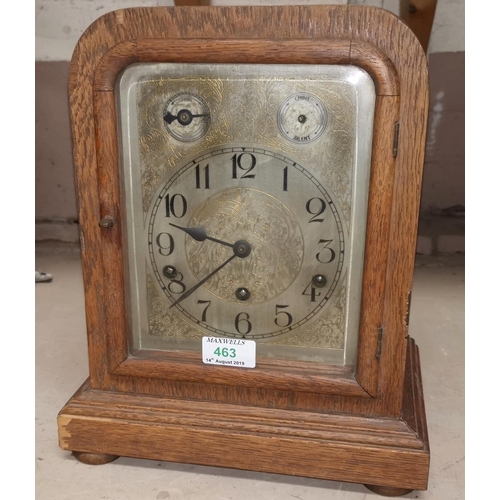 463 - An Edwardian oak cased mantel clock with silvered dial and chiming movement