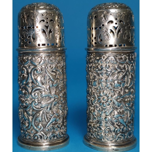 297 - A pair of heavily embossed pepper pots, London 1901, 4.4oz