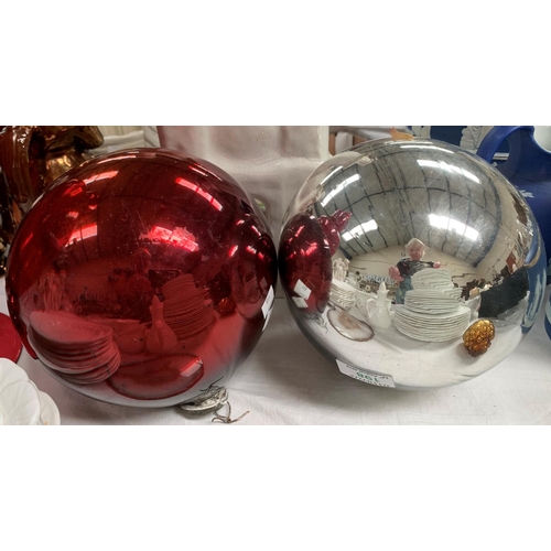 198 - A large silvered glass mirror ball; another in red glass